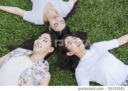 Portrait of elegant ladies lying on the green grass. 30193881