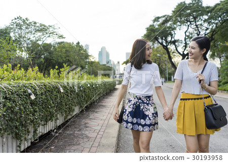 Both of women are hand in hand on the street. Both of women are hand in hand on the street. 30193958