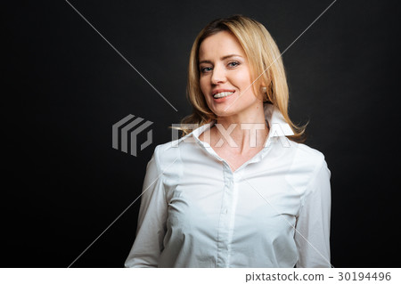 Smiling woman standing isolated against black Smiling woman standing isolated against black 30194496