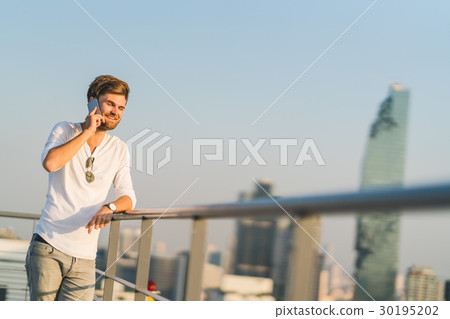 White man using mobile phone at rooftop White man using mobile phone at rooftop 30195202