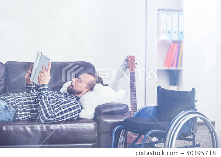 Young disabled relaxing on the sofa and enjoying 30195718