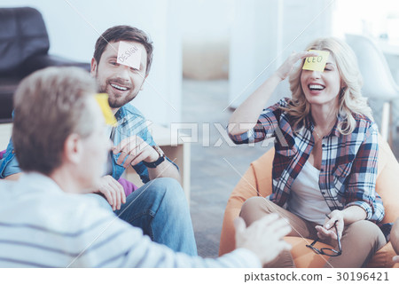Cheerful colleagues playing game with stickers on Cheerful colleagues playing game with stickers on 30196421