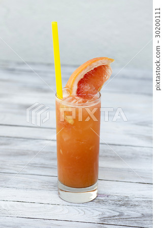 Grapefruit lemonade in a glass with ice on wood Grapefruit lemonade in a glass with ice on wood 30200111