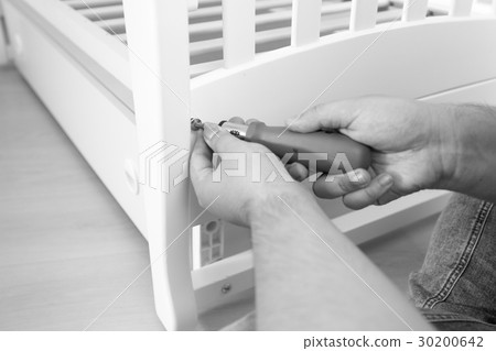 Closeup photo of man tightening the screws 30200642
