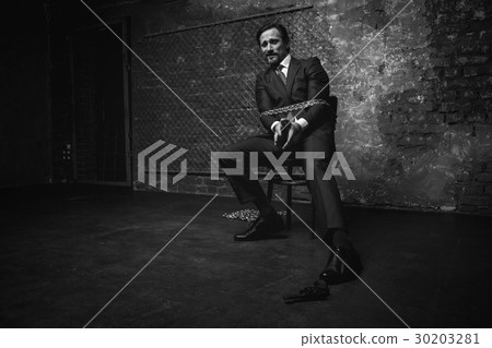 Pathetic chained up man making attempts reaching a 30203281