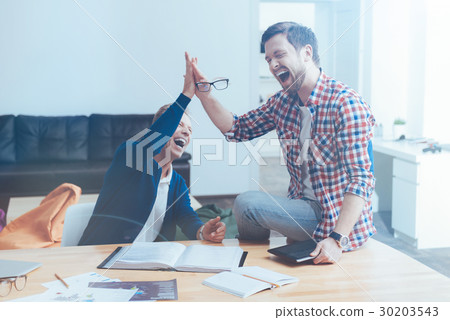 Overjoyed smiling colleagues sitting in the cafe Overjoyed smiling colleagues sitting in the cafe 30203543