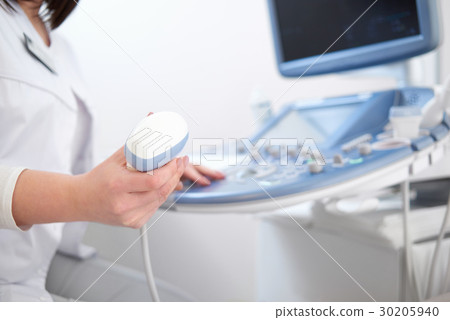 Beautiful female doctor sitting in her office near 30205940