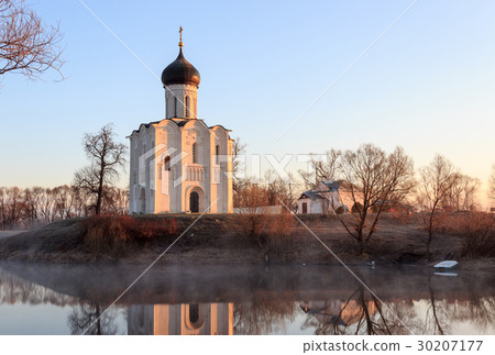 A misty lake with a boat in front of the church A misty lake with a boat in front of the church 30207177