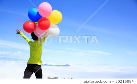 woman with colorful balloon on mountain peak woman with colorful balloon on mountain peak 30216094
