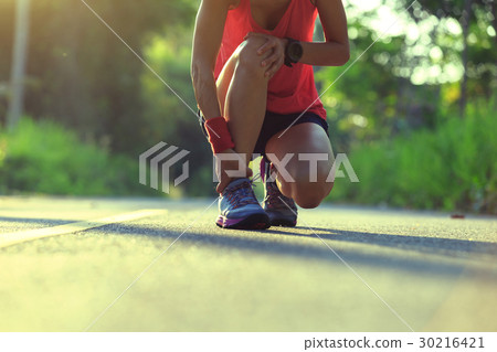 woman runner got sports injury on knee 30216421
