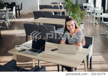 Adult woman sitting at the desk with a laptop and 30218379