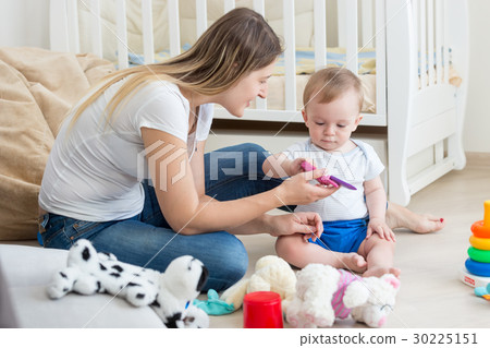 Baby playing on floor at living room with mother Baby playing on floor at living room with mother 30225151