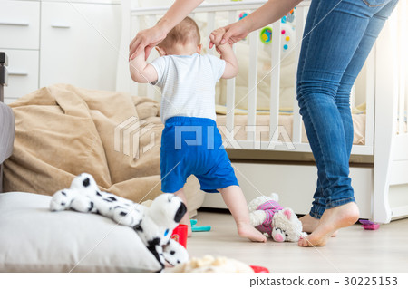 Adorable baby making first steps with mother 30225153