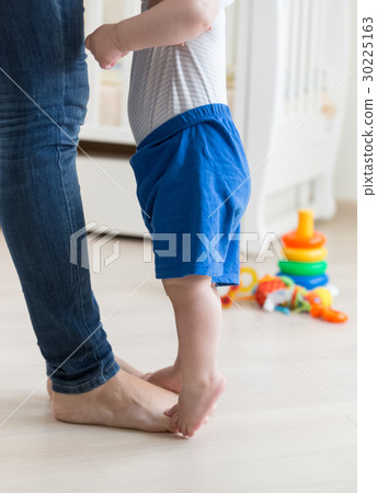 Baby standing on tiptoes and reaching for his mom Baby standing on tiptoes and reaching for his mom 30225163