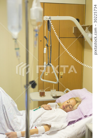 Bedridden female patient recovering after surgery 30225734