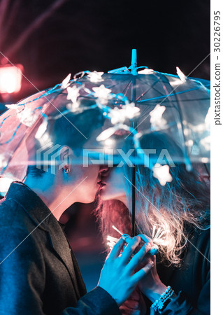 Guy and girl kissing under an umbrella Guy and girl kissing under an umbrella 30226795