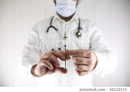 Crazy doctor in a white coat and old syringe 30228315