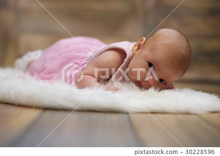 Newborn cute baby lying on white fur skin 30228596