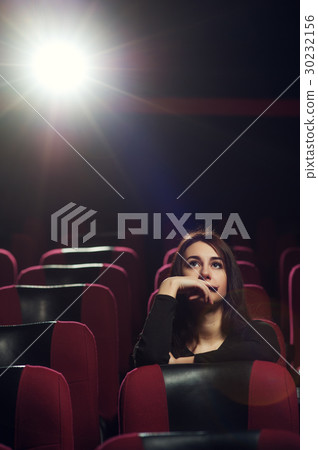 Beautiful brunette girl sitting in cinema theater Beautiful brunette girl sitting in cinema theater 30232156