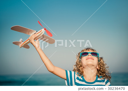 Happy child playing with toy airplane 30236470