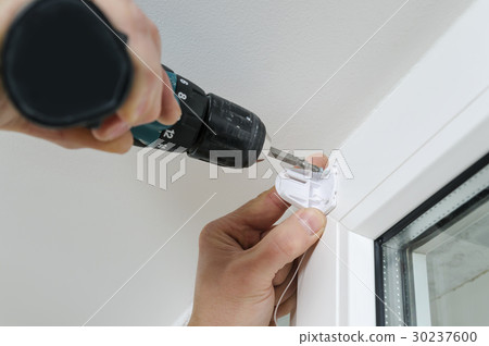 Installing roller blind on a window. Installing roller blind on a window. 30237600