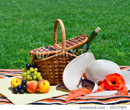 Picnic basket with fruits on green sunny lawn. Picnic basket with fruits on green sunny lawn. 30237995