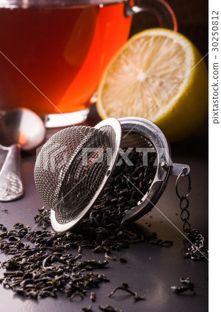 tea strainer with a cup on dark background 30250812