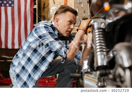 Great handsome mechanic focused on his work Great handsome mechanic focused on his work 30252729