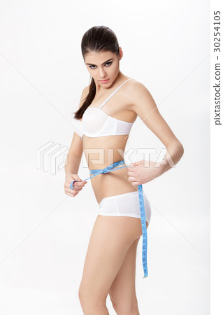 young beautiful brunette woman measuring her young beautiful brunette woman measuring her 30254105