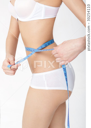 young woman measuring her perfect slim body iwith 30254110
