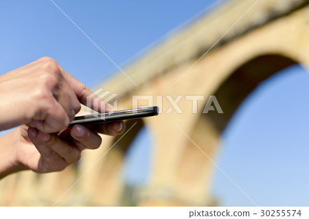 man using a smartphone outdoors 30255574