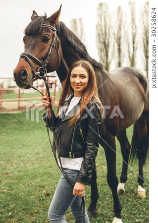 Beautiful girl communicates with a horse in the 30258624
