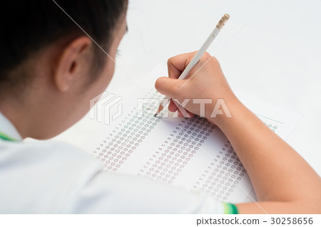 Student filling out answers to a test with pencil 30258656