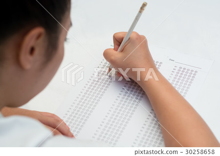 Student filling out answers to a test with pencil 30258658