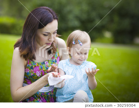 Mother using wet wipes for her daughter Mother using wet wipes for her daughter 30259304
