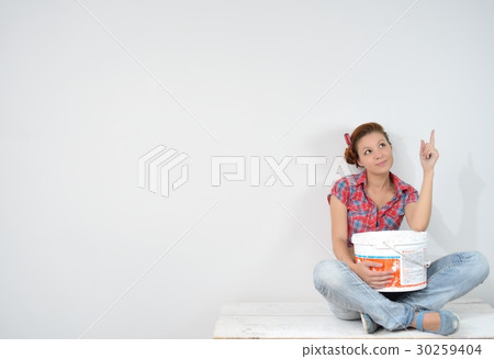 Beautiful young woman with paint bucket thinks over idea of repair 30259404