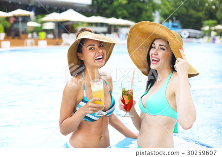 Happy girls with drinks on summer pool party  30259607