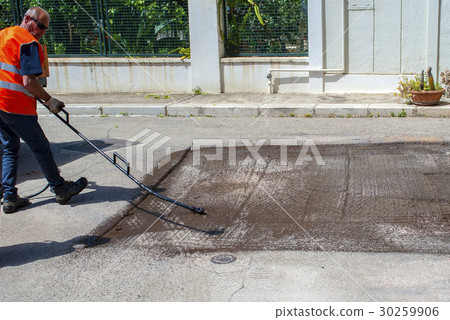 Road worker spraying bitumen emulsion Road worker spraying bitumen emulsion 30259906