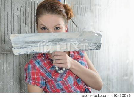 Young beautiful girl with pallets stay near the repaired wall 30260056
