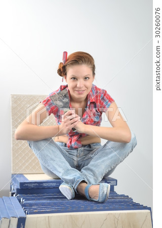 Young beautiful woman sits and plays the fool at the time of repair Young beautiful woman sits and plays the fool at the time of repair 30260076