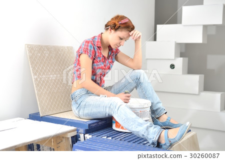 Young beautiful woman sits and thinks of repair Young beautiful woman sits and thinks of repair 30260087