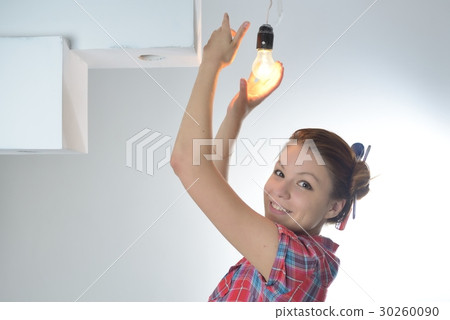 Young beautiful woman twists a bulb 30260090