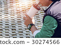 man using a straw to drink water from  plastic cup 30274566