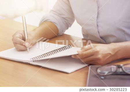 Business woman hand writing on notebook . Business woman hand writing on notebook . 30285223