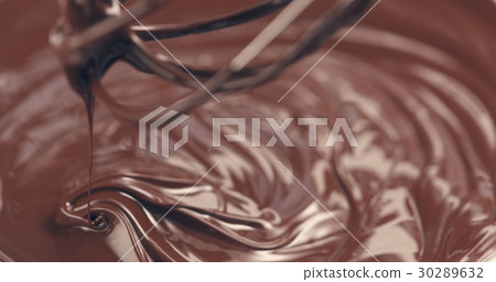 mixing melted premium dark chocolate with a whisk 30289632