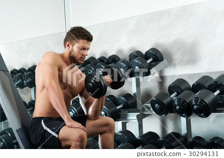 Handsome young athlete working out at the gym  30294131