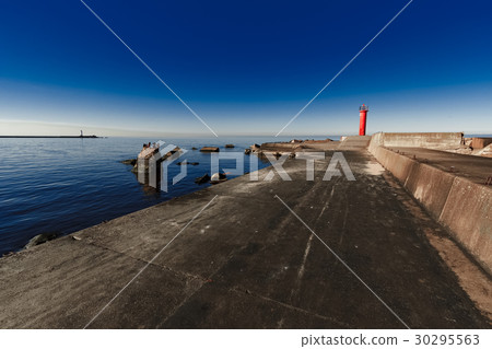Red lighthouse on breakwater dam 30295563