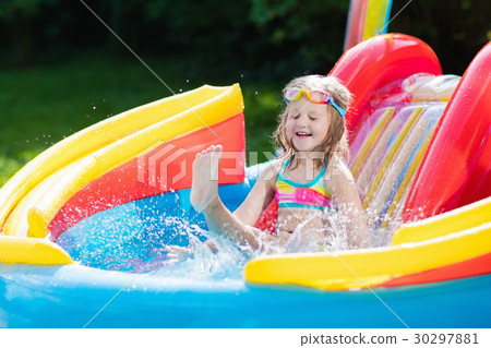 Child in garden swimming pool with slide 30297881
