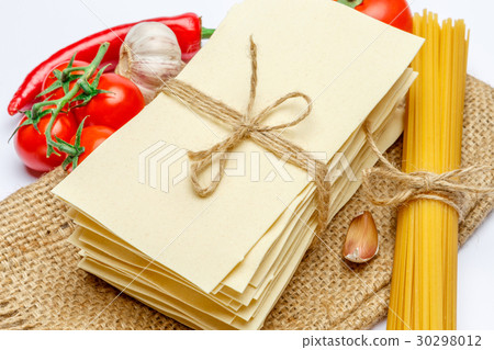 pile of dried uncooked lasagna pasta sheets and 30298012