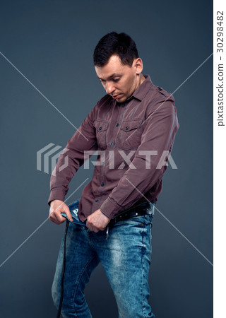 Man unbuttoned pants and looking at his penis 30298482